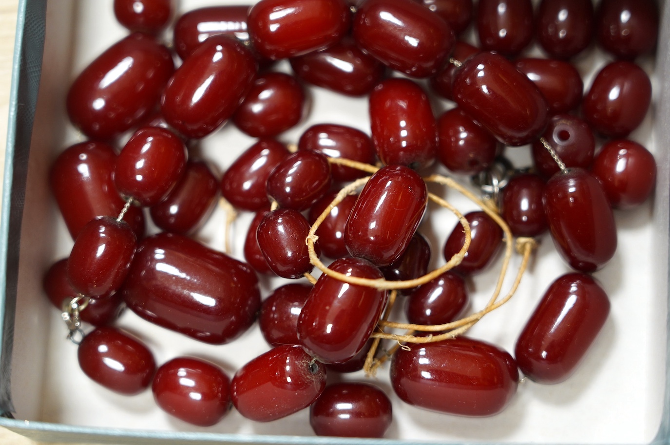 A simulated cherry amber bead necklace, (needs re-stringing), gross weight 136 grams. Condition - poor